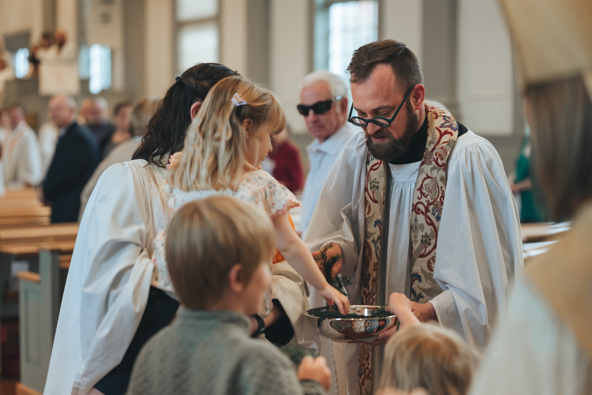 Clergy blessing a family during worship at Christ Church Episcopal Hudson